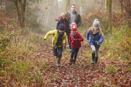 Family out for a walk in fall forest.