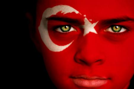 Image of young boy with Turkish flag painted on face and the inside of the Turkish Assembly building