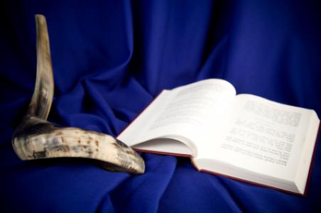 The shofar, an instrument used to blow sound, is pictured with a Jewish holy book.
