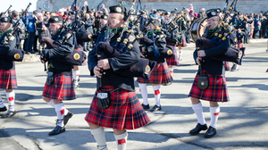 Marching band with men in kilts with bagpipes.
