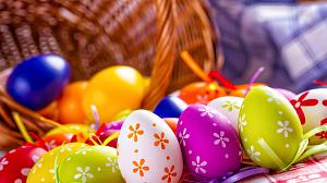 Dozens of colorful Easter eggs pouring out of a basket.