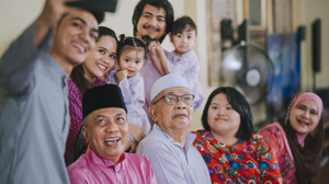 A family of Malaysian Muslims in colorful clothes taking a selfie.