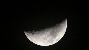 Close-up of a half moon seen on black space background at night.