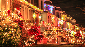 View of row of houses heavily decorated with colorful Christmas lights.