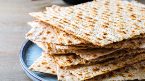 Closeup of a stack of traditional jewish flatbreads on a plate on a wooden table.