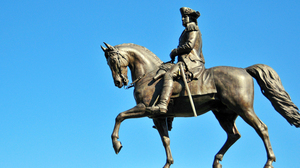 Statue of General George Washington sitting on a horse, blue sky in the background.