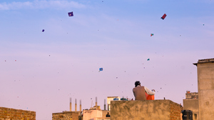 Families flying kites from the rooftops of their old brick buildings in the old city of Jaipur. This is a popular sport of Makar Sankranti and Independence Day.