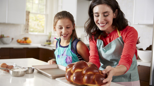 Mother and daughter hold a freshly baked challah.