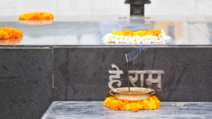 Close-up of the Mahatma Gandhi memorial Raj Ghat with yellow flowers and insense.
