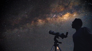 Astronomer with a telescope looking at the stars.
