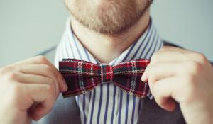 Close-up portrait of a man correcting bowtie.