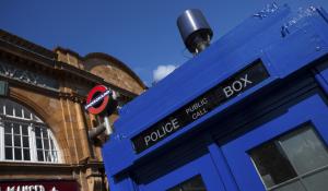 Police box with a modern surveillance mounted camera near Earl's Court tube station in London.