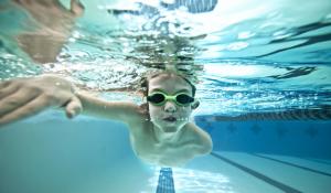 Underwater shot of boy swimming laps in a swimming pool.