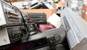 Old stereos and electronics pile up at a recycling event.