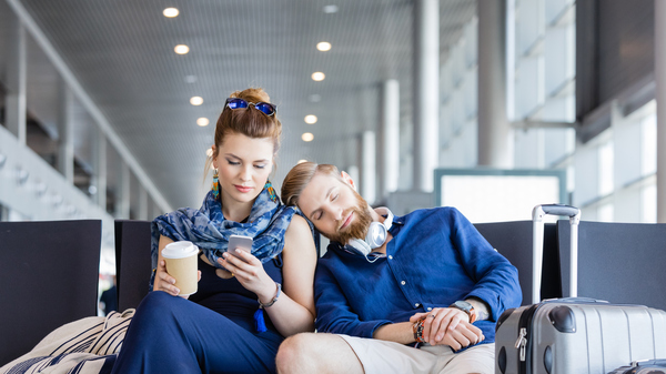A young couple relaxing in an airport lounge.