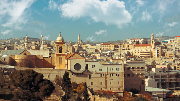 A view of the historical part of Bethlehem. Sand colored houses, churches, and historical buildings.
