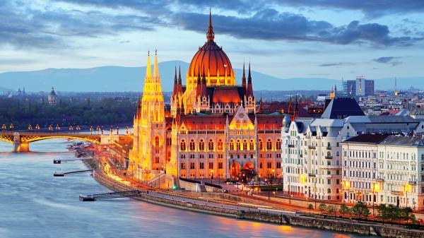 Lit up Hungarian Parliamentary building next to the Danube river.