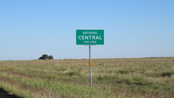 Green roadsign reading "Entering Central Time Zone"