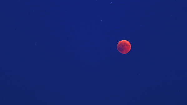 A view of a total lunar eclipse in the evening sky.