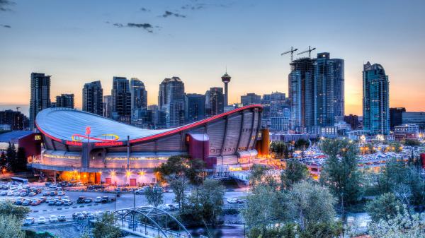 Sunset over the skyline of Calgary in Alberta, Canada with the Scotiabank Saddledome in the foreground.
