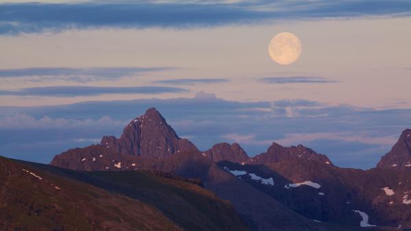 Blasser Vollmond am Abend über Bergen in Lofoten, Norwegen