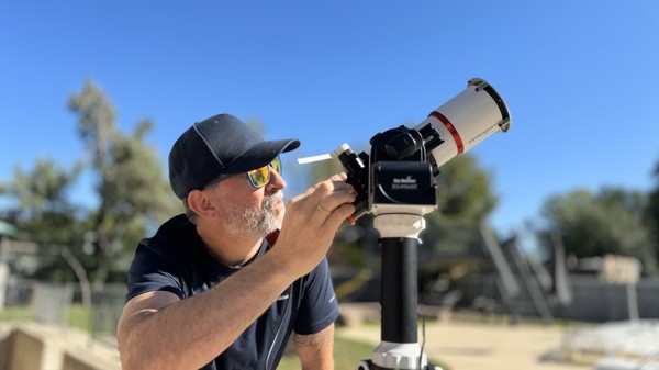 A man adjusting a solar telescope.