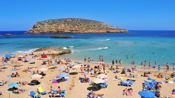 Sunbathers at Cala Conta beach in San Antonio, Ibiza, Spain.