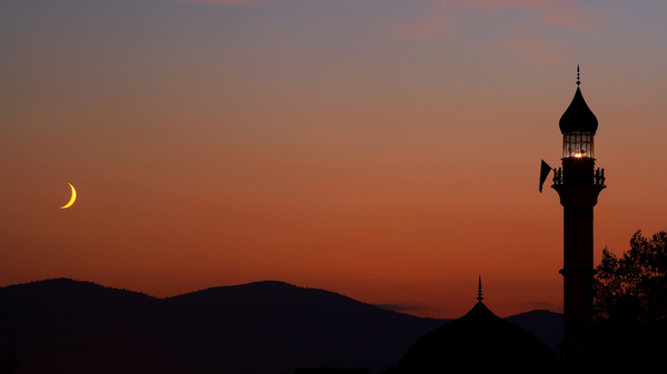 Mosque at dusk with crescent Moon