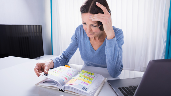 Woman reading a notebook calendar