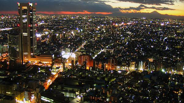 Twilight view over Tokyo metropolis with Mount Fuji on the horizon, back lighten by sun.