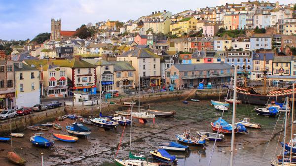 Small boats moored at low tide in the fishing port in Brixham, Devon, UK