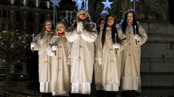 Malmo’s Lucia 2015, Matilda Strom, leads her entourage in song on Stortorget square, dressed in white robes and holding candles.