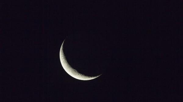 A Waining Crescent Moon against a black night sky illuminated from the left side.