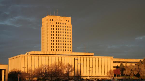 North Dakota capital tower with Department of Transportation building in foreground in early morning light.