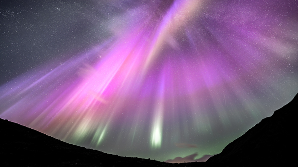 A view of vibrant purple northern lights over Harstad, northern Norway.