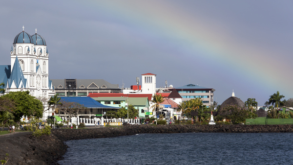 A view of Apia’s harbor with a rainbow in the sky showcases Samoa’s vibrant culture and natural beauty. In 2011, Samoa shifted its time zone to align with Australia and New Zealand, strengthening ties in a radical change.