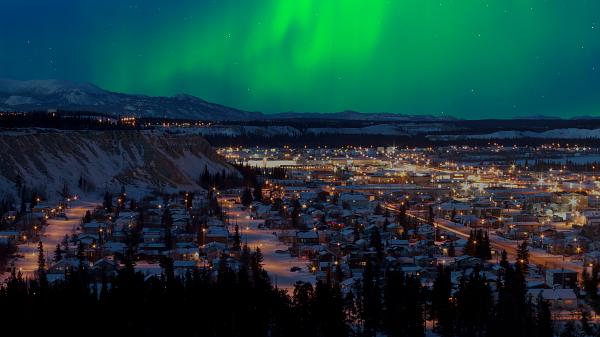 Strong northern lights (Aurora borealis) in the night sky over downtown Whitehorse, capital of the Yukon Territory, Canada, in winter.