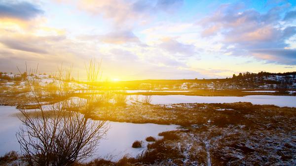Solnedgang over vinterlandskap.
