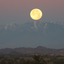 A Full Moon sets behind the Atlas Mountains in Morocco.