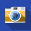 A photo camera casting shadow on a blue background.
