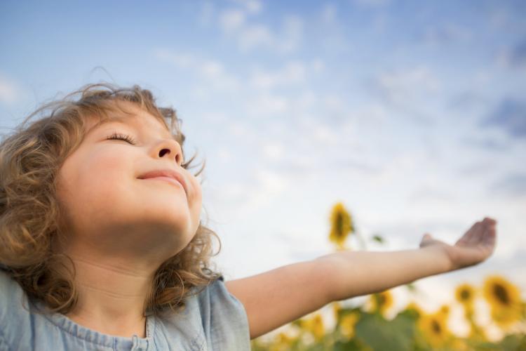 A child with his arms spread wide to the world.