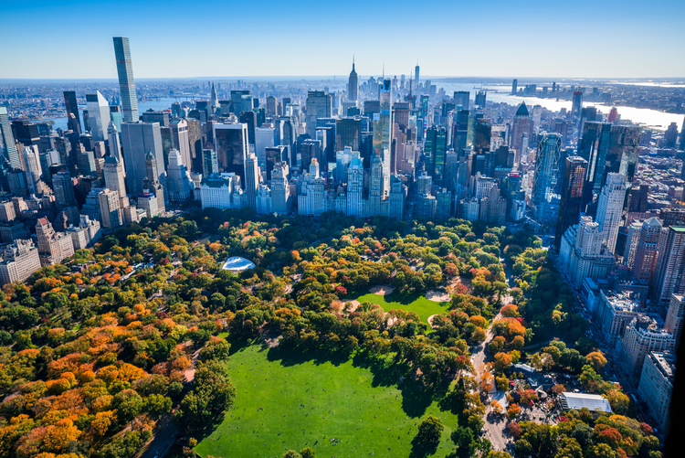 New York City skyline aerial view with Central Park in foreground and Manhattan cityscape skyline in background. Colorful autumn foliage in Central Park.