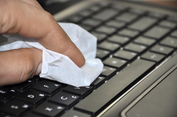 Hand cleaning computer with a cloth.
