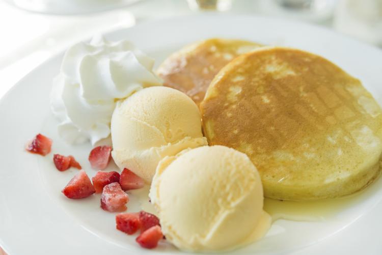 Pancakes with ice cream and golden maple syrup.