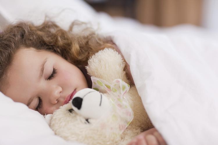 Girl sleeping with her teddy.