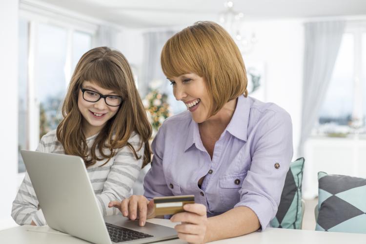 Mother and daughter shopping online at home during Christmas.