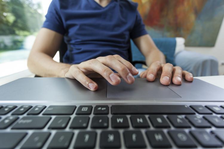 Student behind computer keyboard.