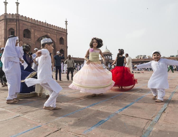 Smilende barn danser utenfor historiske Jama Masjid nær Red Fort i New Delhi i India i forbindelse med feiringen av den islamske høytiden id al-fitr.