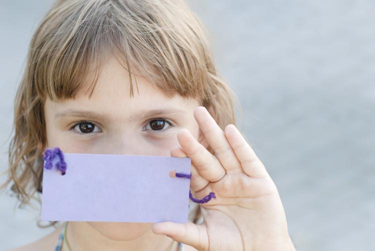 Kid holding up a name tag.