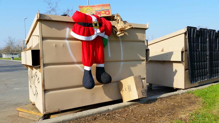 Santa suit discarded in a trash can.